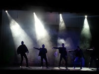 a group of dancers on stage with smoke coming out of their eyes