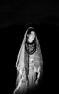 a black and white photo of a woman in a blanket