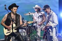 a group of men in cowboy hats playing guitars