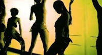 a group of people dancing in a yellow room