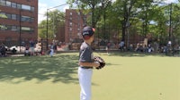 a young boy is standing on a baseball field