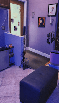 a living room with purple walls and a black bench