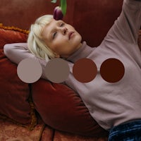 a woman laying on a couch with a tulip in her hand