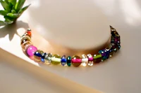 a multi colored beaded necklace on a mannequin