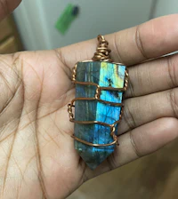 a person holding a labradorite pendant