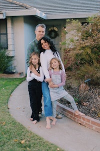 a family posing for a photo in front of their home