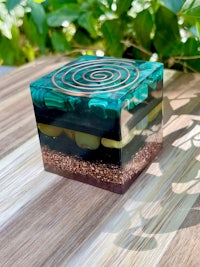 a blue and green glass box sitting on a wooden table