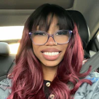 a woman wearing glasses and a burgundy wig