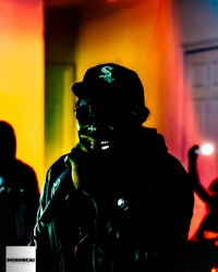 a man is holding a microphone in front of colorful lights