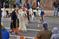 a group of native americans walking down the street