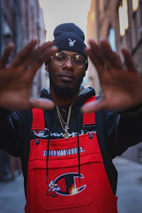 a man in overalls with his hands up in the air