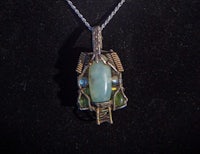 a pendant with a green stone on it