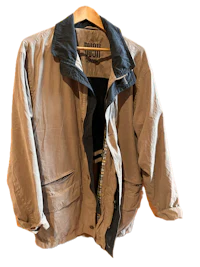 a beige jacket hanging on a hanger