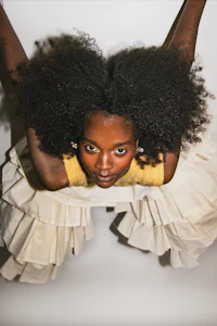 a woman with afro hair in a white dress