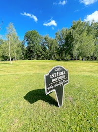 a sign in the middle of a grassy field