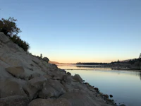 a large body of water with rocks on the shore