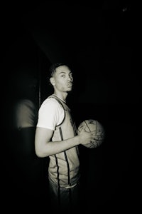 a black and white photo of a basketball player holding a ball