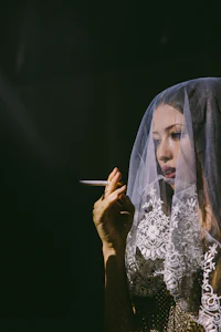 a woman in a veil smoking a cigarette