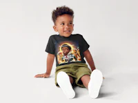 a young boy sitting on the floor wearing a black t - shirt