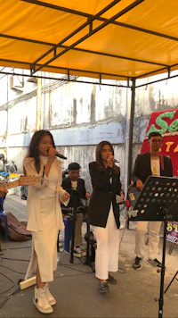 a group of people standing under a yellow tent