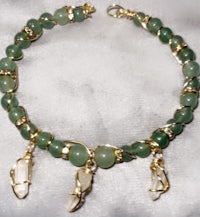 a green jade beaded bracelet with gold charms