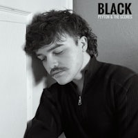 a man with a mustache leaning against a door