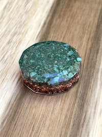 a round green stone on top of a wooden table