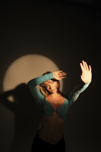 a woman is posing in front of a light