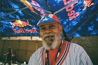a man with a beard and a red bull hat