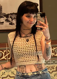 a woman with tattoos taking a selfie in a bathroom