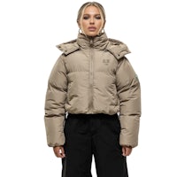 a woman wearing a beige puffer jacket and black pants