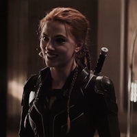 a woman in a black widow costume is holding a sword