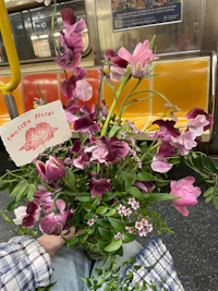a person holding a bouquet of flowers on a subway platform