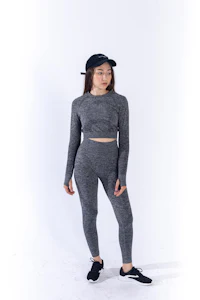 a woman wearing a grey long - sleeved top and leggings