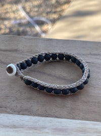 a black beaded bracelet on a wooden table