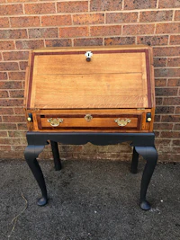 a desk with a wooden top and legs in front of a brick wall