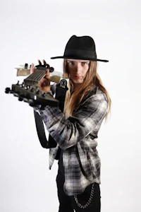 a woman in a hat holding a guitar