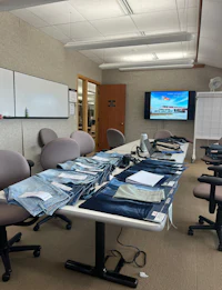 a room with a table and chairs and a large screen