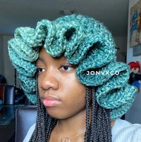 a woman wearing a crocheted ruffled hat