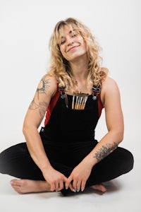 a woman with tattoos sitting on the floor