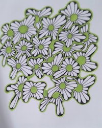 a white and green sticker with daisies on it