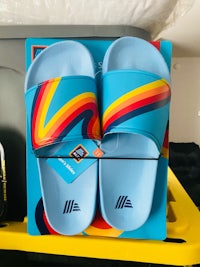 a pair of blue slide sandals sitting in a box