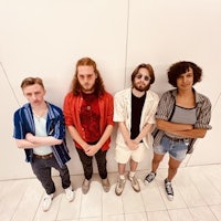 a group of people standing in front of a white wall