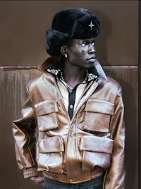 a man wearing a brown leather jacket and hat