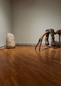 a room with two sculptures and a wooden floor