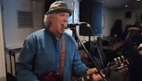a man in a hat singing into a microphone