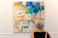 a woman looking at an abstract painting