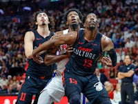 two basketball players are fighting for the ball in a game