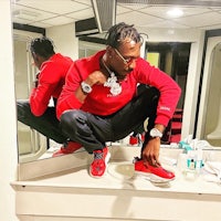 a man tying his shoes in a bathroom mirror