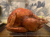 a turkey is sitting on a rack in a kitchen